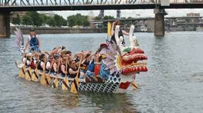 The PKSCA's original Traditional-style Dragon Boat with full crew paddling on the Willamette River. About the History of the PKSCA Section.
