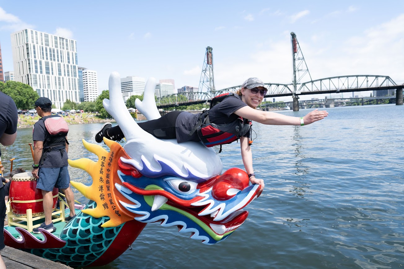 Traditional-Style Dragon Boat head at the Dock with a person in position to catch a flag.